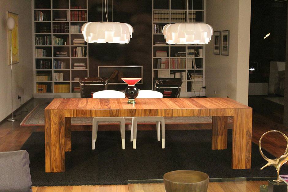 rectangular brown wooden table beside two white armless chairs